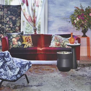 living room with red sofa floral cushion blue floral chair and plant