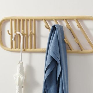 Rattan Wall Hooks with a blue towel and a white umbrella hanging from it