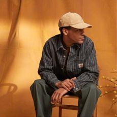Model wearing a Carhartt shirt and hat