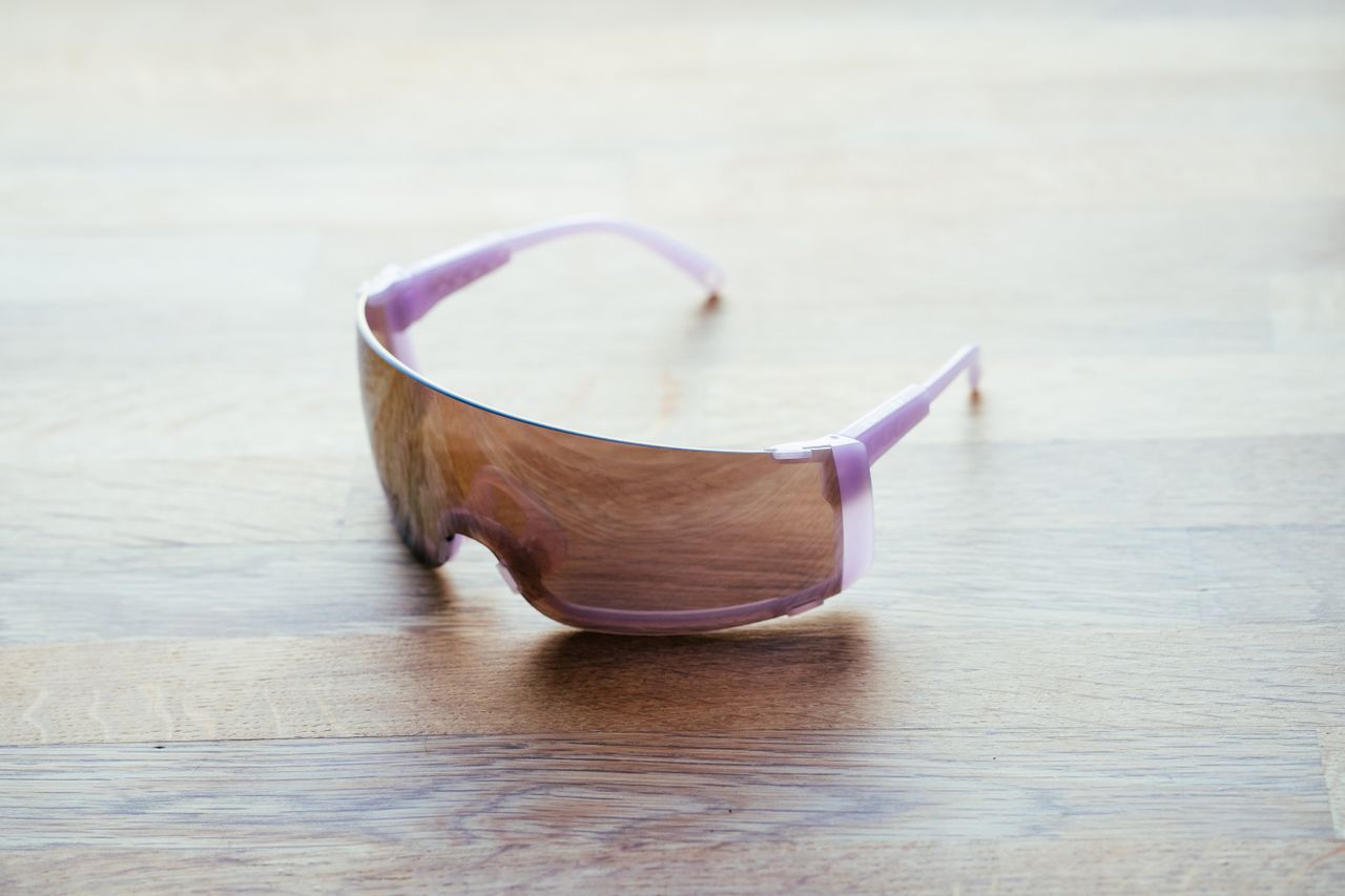 A space-age looking pair of wraparound cycling glasses on a wooden surface