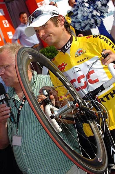 Frank Schleck makes his way through the crowds with his bike