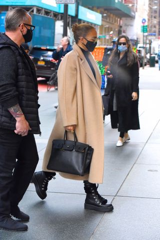 jennifer lopez wearing a Birkin bag coordinating with black boots in 2020.