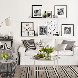 Black and white living room with prints displayed on picture ledges