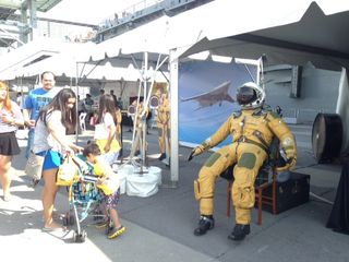 A suit sits inside a NASA booth at the Intrepid Museum's Space & Science Festival