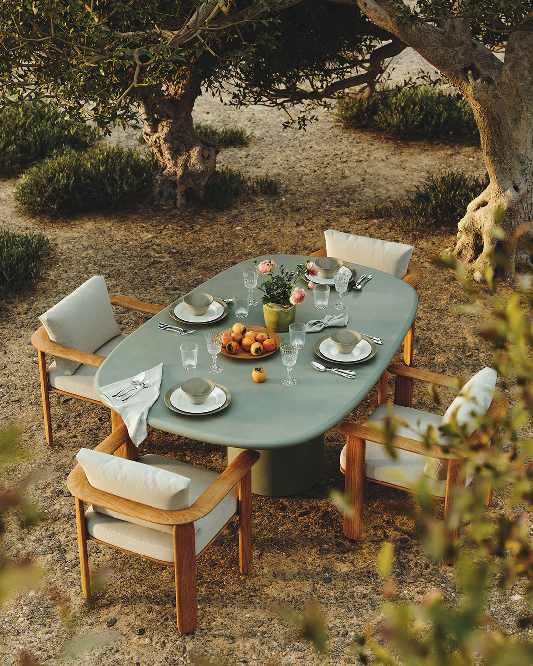 a green plaster outdoor dining table set with a dinner service