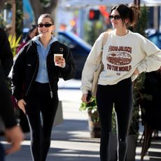 Hailey bieber and kendall jenner wearing leggings and a sweatshirt.