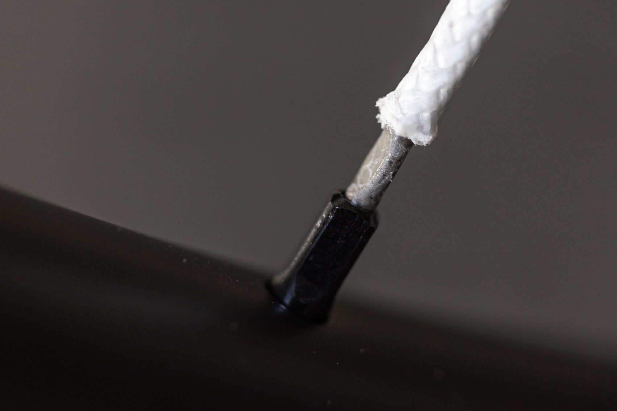 close up of a white polylight spoke and black nipple