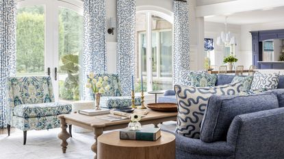 Living room with blue sectional with pillows, coffee table at seat height and blue patterned armchairs