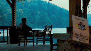 A man sitting in a chair overlooking a lake in Dirty Dancing.