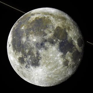 a detailed view of the moon with saturn passing behind it then reappearing.