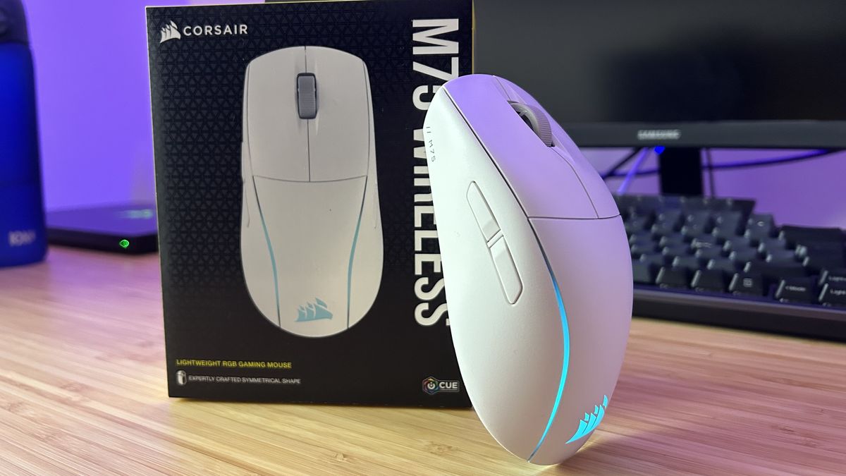 Corsair M75 Wireless gaming mouse leaning against the product box on a wooden desk