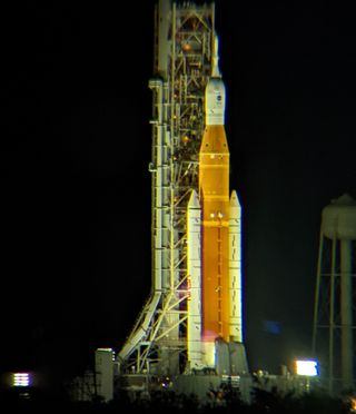 An image of the Artemis 1 mission's Space Launch System rocket on the launch pad 3.2 miles (5.14 km) away, as viewed through Celestron Skymaster binoculars.