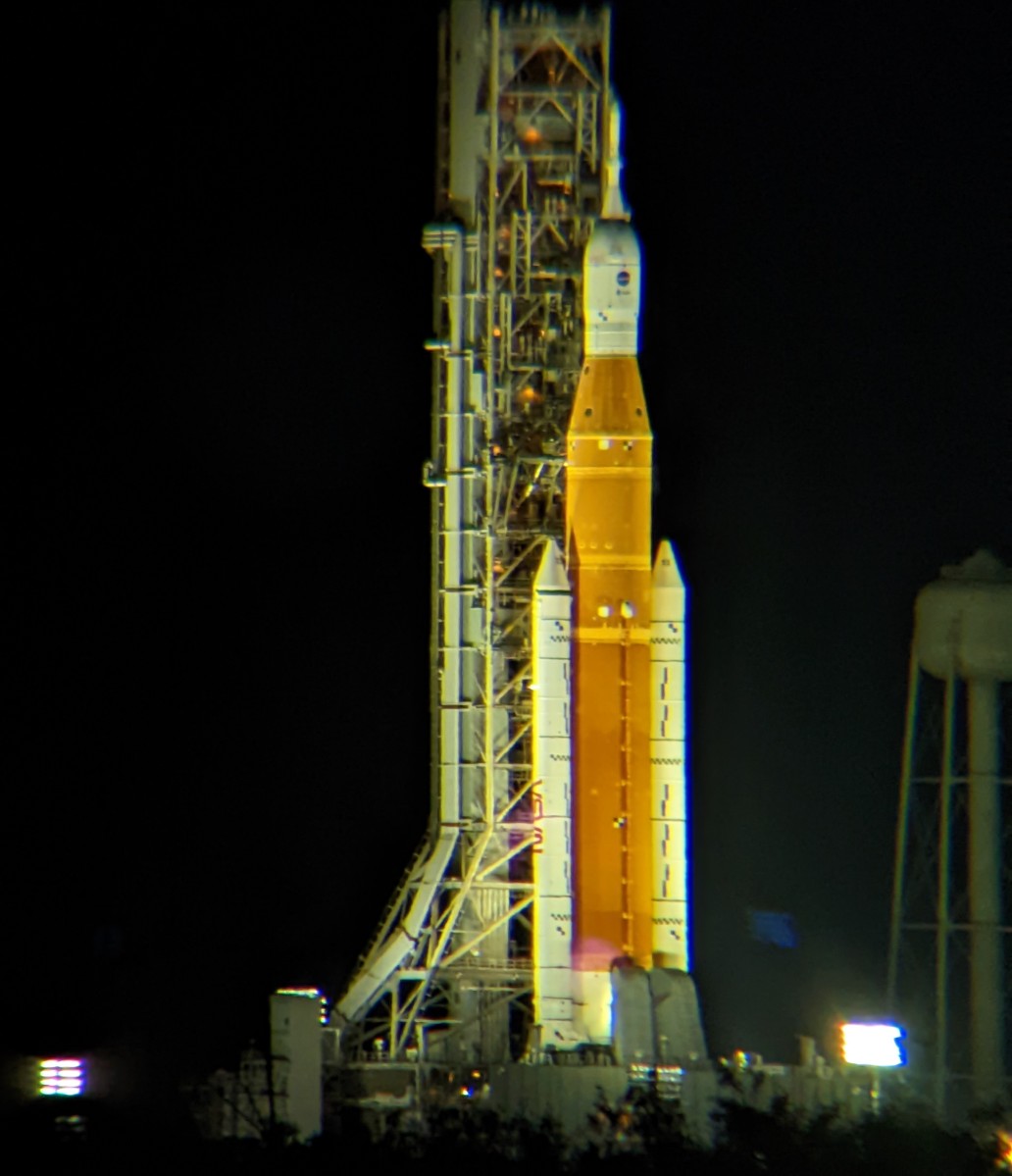 An image of the Space Launch System rocket from the Artemis 1 mission on the launch pad 3.2 miles (5.14 km) away, seen through Celestron Skymaster binoculars.