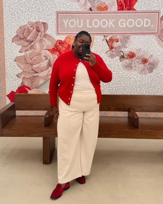 @abimarvel wearing a red cardigan with white trousers and top