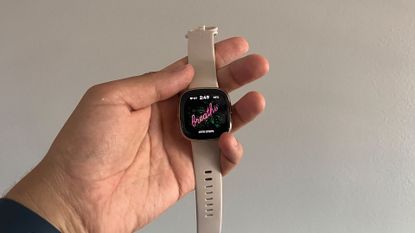 Person holding the Fitbit Sense smartwatch