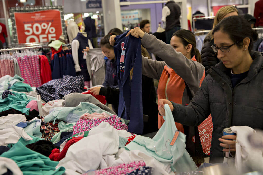 Shoppers look at clothes in a Vineyard Vines store at the Fashion Outlets of Chicago mall in Chicago, Illinois, U.S