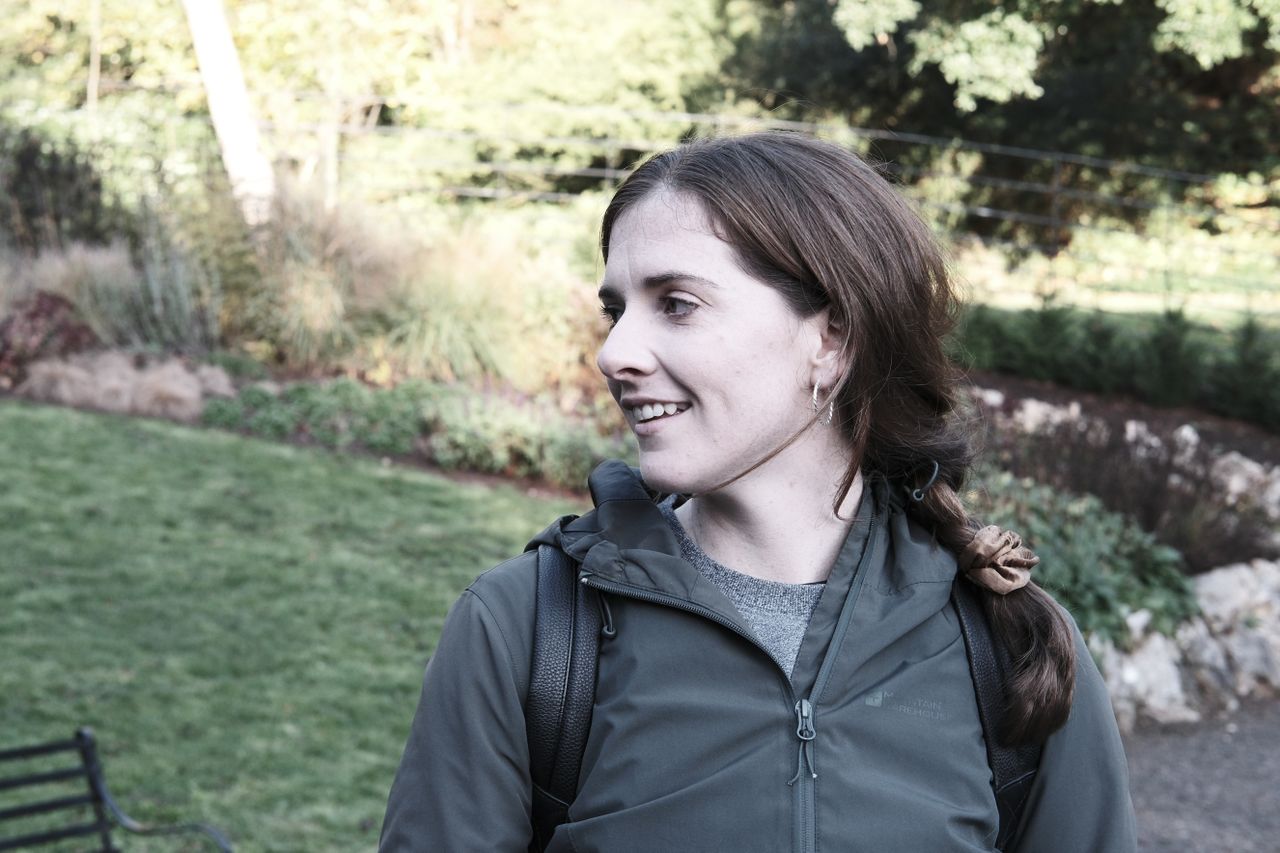 A photo of a woman looking over her shoulder and smiling.