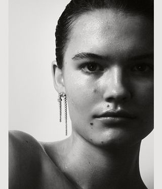 Woman with wet slicked hair wearing a long diamond earring