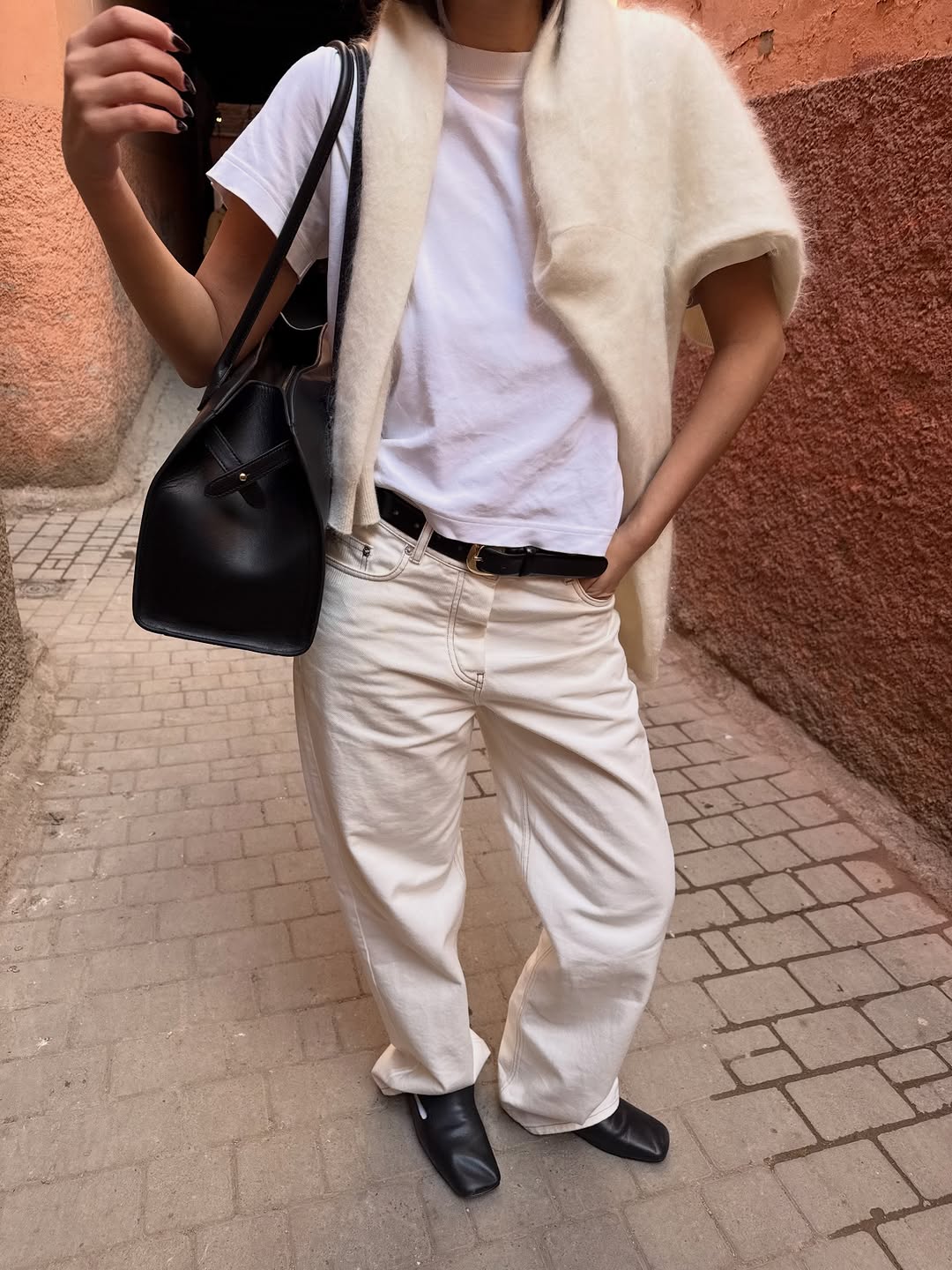 A woman wearing all white essentials, one of the biggest 2026 spring to summer transitional trends.