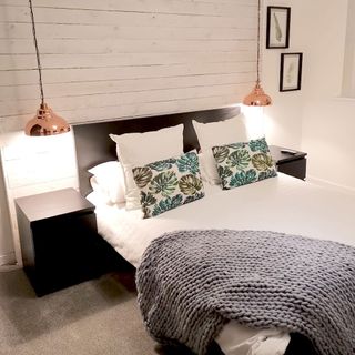 bedroom with hanging lamp light and side table