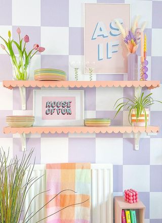 Floating scalloped shelves on a wall with a purple checkerboard pattern