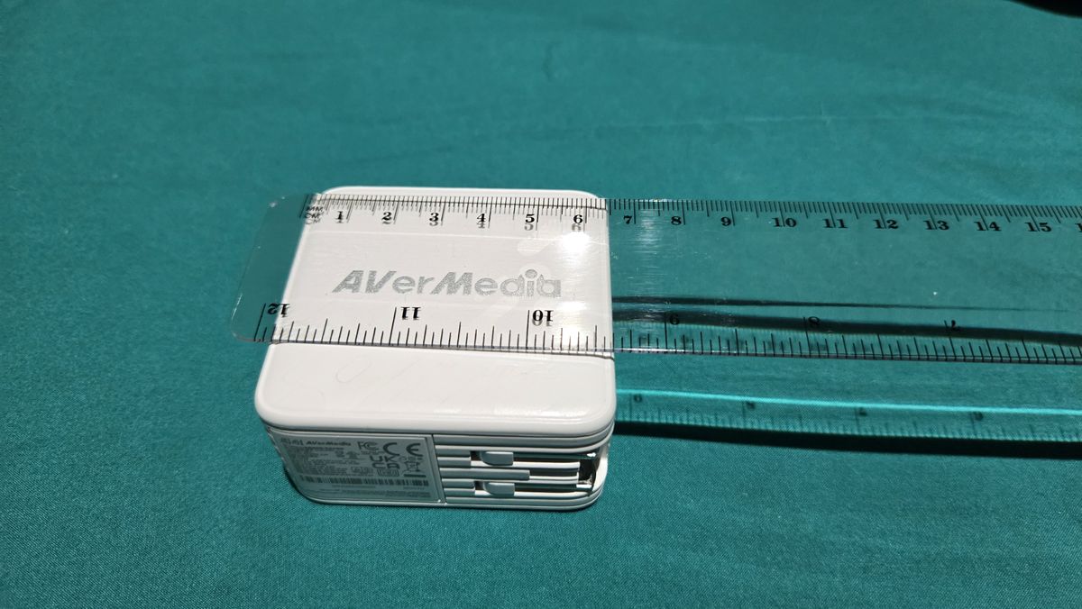 AVerMedia Elite Go GC313Pro on a turquoise sheet with cables.