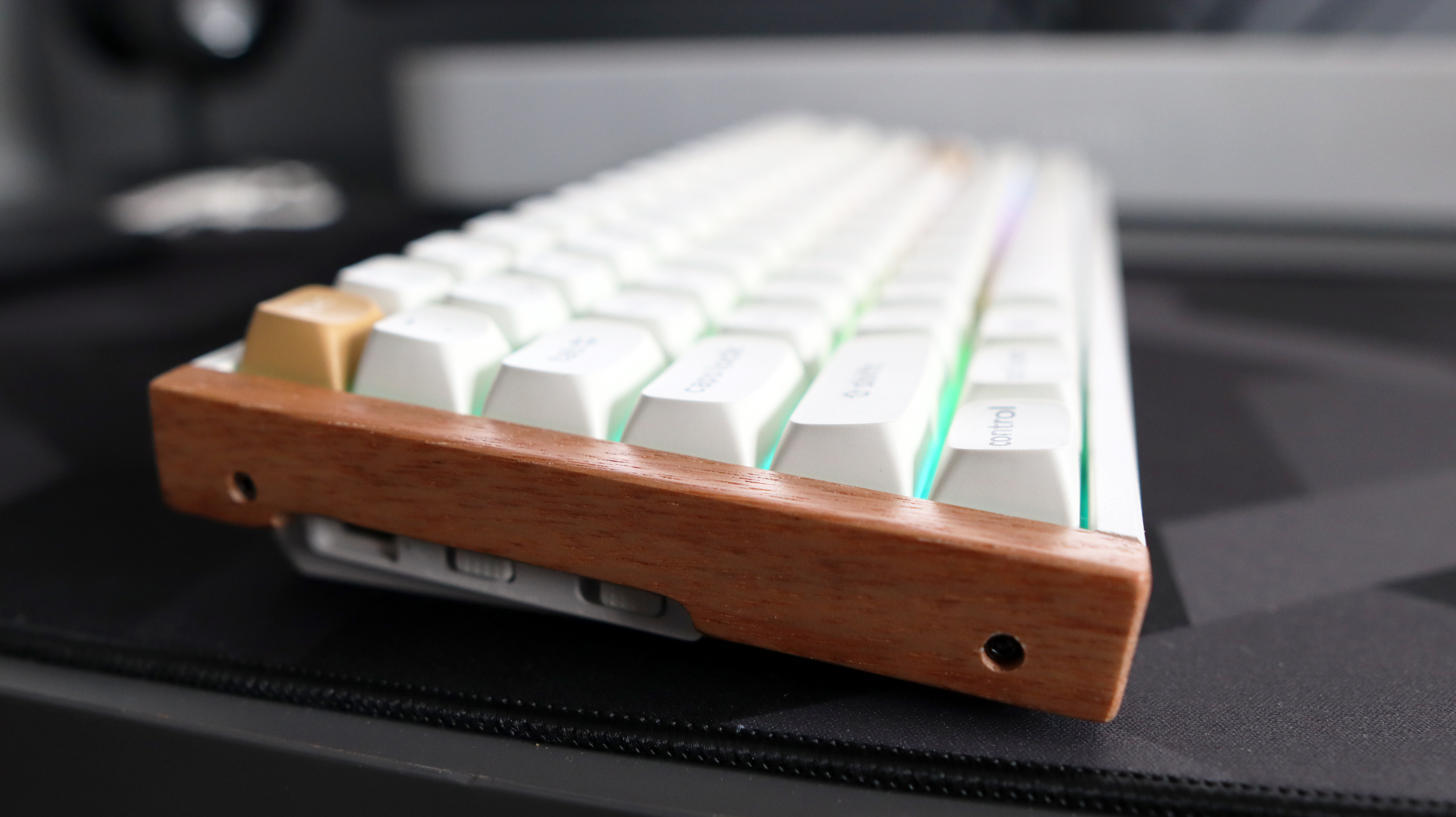 A Keychron K2 HE gaming keyboard with a wood finish and white keycaps with RGB enabled.