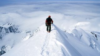 A climber on the snowy summit of Mt Blanc