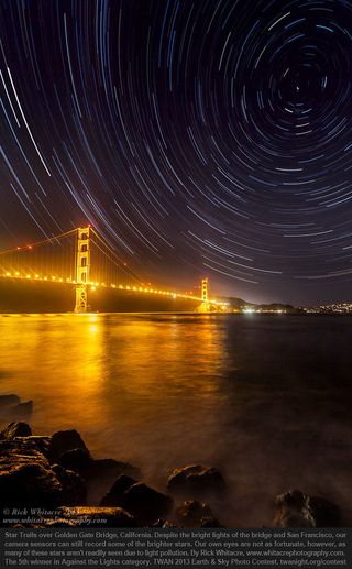 Fifth place in the Against the Lights category goes to “Golden Gate Star Trails” by Rick Whitacre. A well-done photo sequence has captured star trails above the lights of San Fransisco and the Golden Gate Bridge.