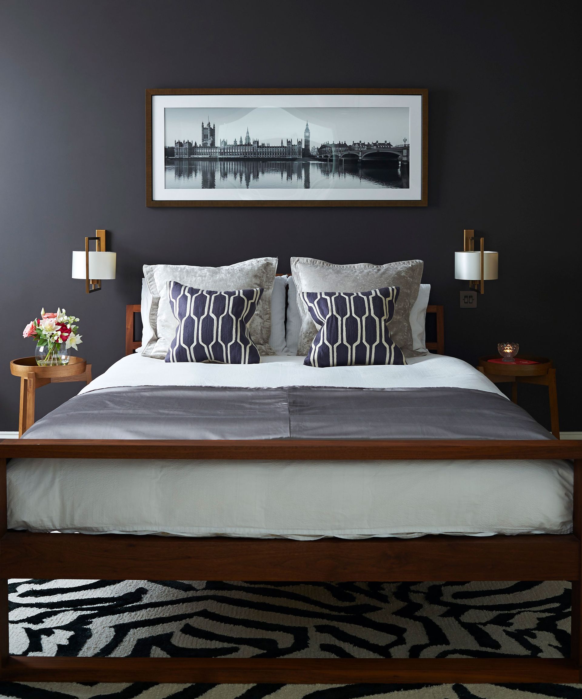 Lighting options in small bedroom ideas illustrated by wall lights in a dark midnight blue scheme.