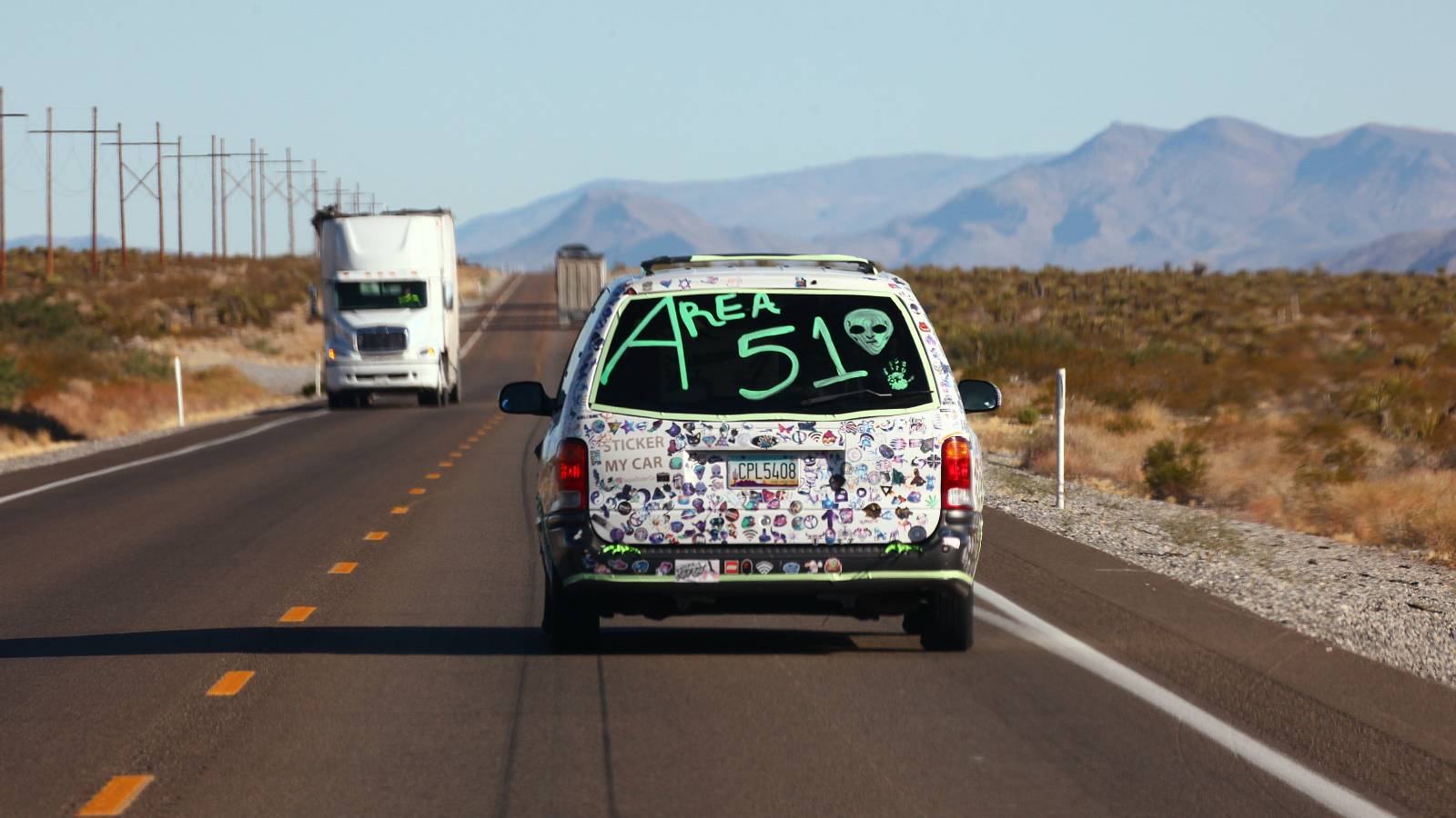 A van with "Area 51" written on the back, on a highway in Nevada.
