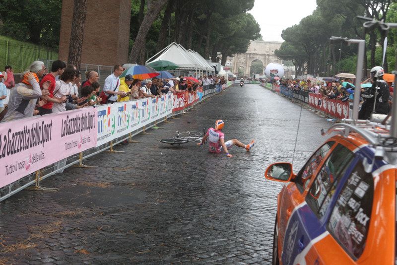 Dennis Menchov crashes on the slippery Roma cobbles during the final day time trial