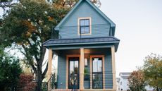 Shotgun style house with painted blue exterior and wood pillars