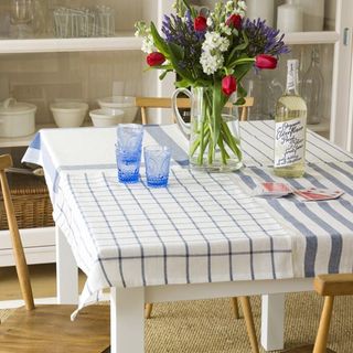 dining table with flower vase and white cupboard