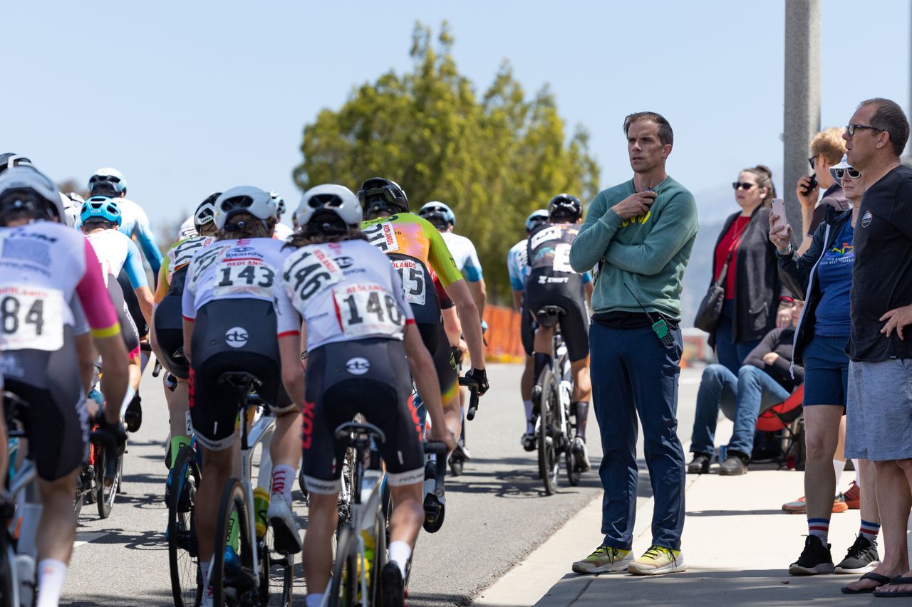 Mike Creed, Director Sportif for Aevolo, watches on as the field makes their way up the Base Line Climb.