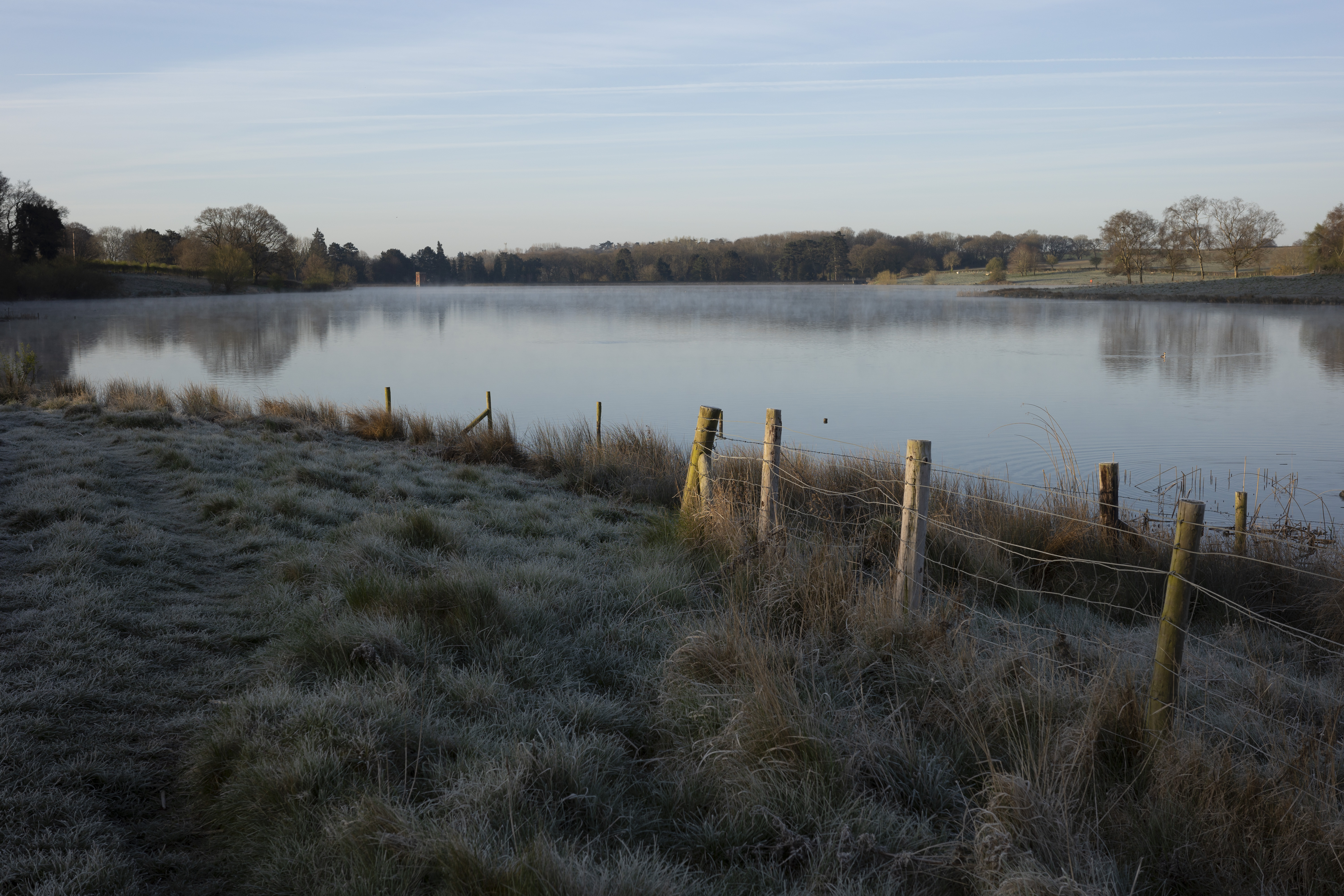 A lake next to a frosty field