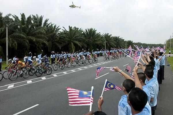The peloton head between some fanatical Malaysian school-children early into the fifth stage.