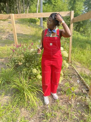 Nikki Ogunnaike wearing a pair of red overalls on a farm