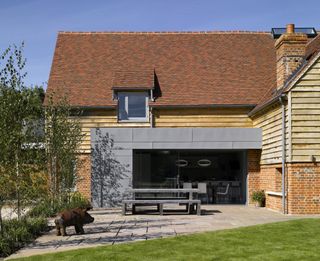 a house with clay roof tiles and a modern extension