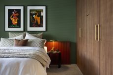 A bedroom with a built-in wardrobe, green walls, and orange wallpanelling