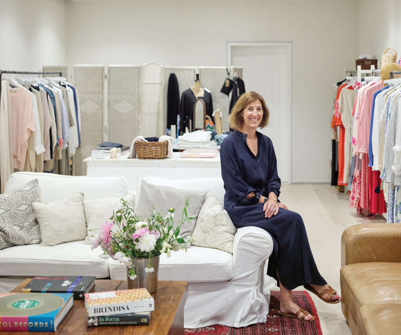 clothes studio with homeowner sitting on white sofa