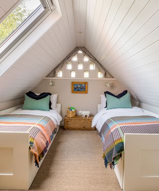 Dovecote bedroom with cladding ceiling in coastal cottage in Northumberland
