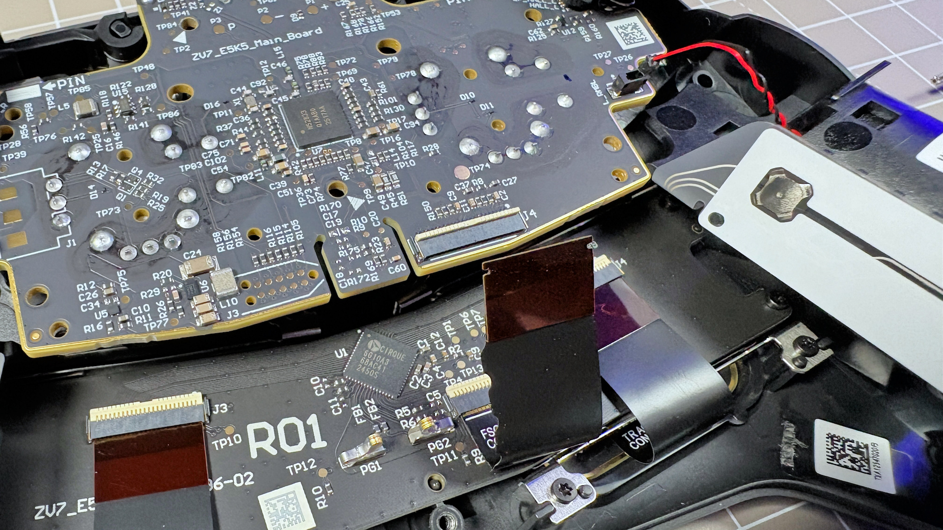 The Steam Controller on a desk during a teardown, with various parts removed.
