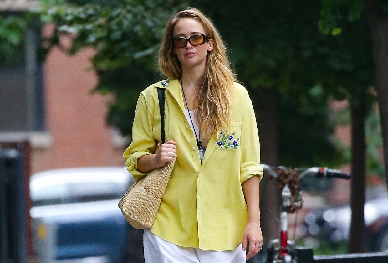 Jennifer Lawrence wears yellow shirt, linen pants, sunglasses and fisherman sandals while walking on the street in NYC.