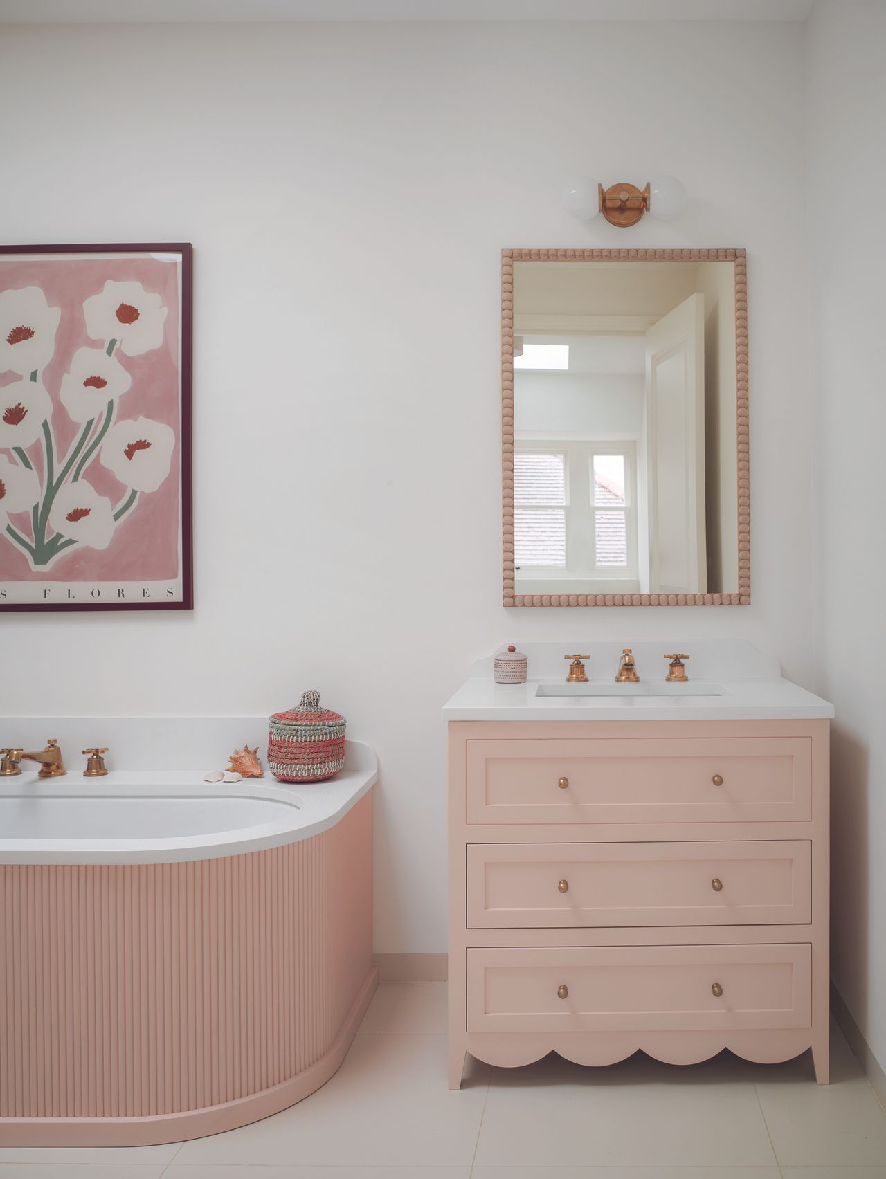 The pink and white bathroom with a scalloped edge basin unit