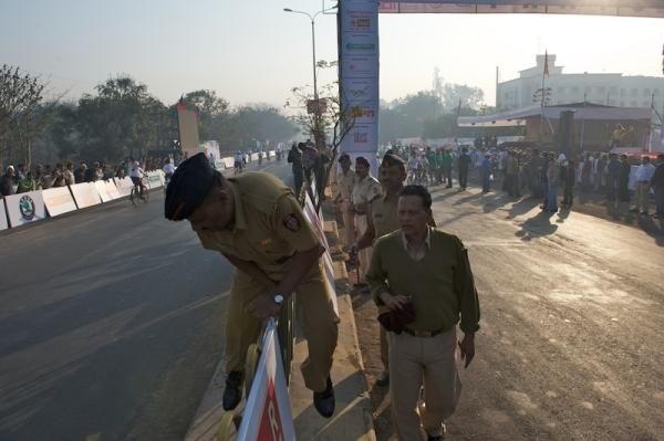 A local police officer climbs a barrier