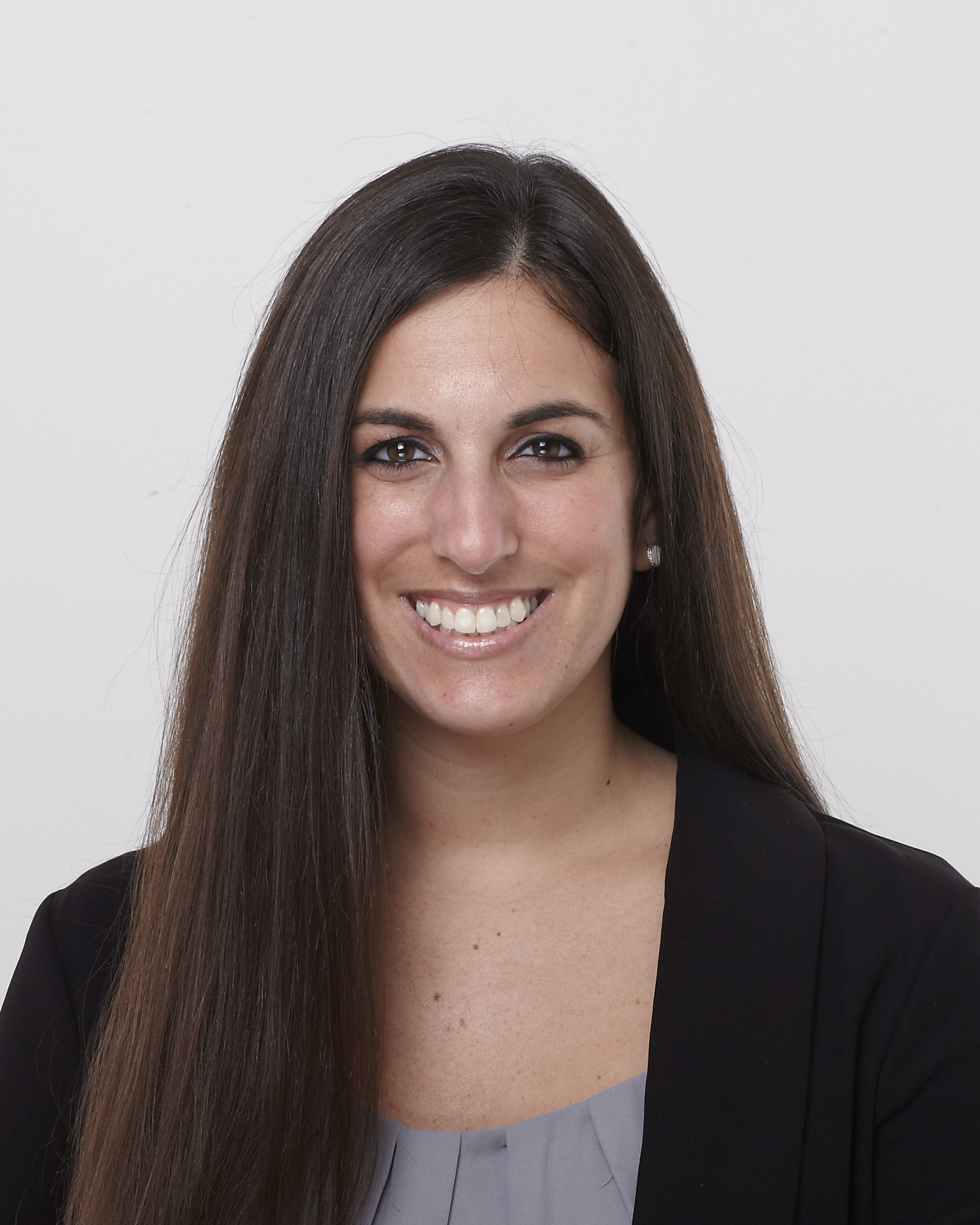 a white woman with dark brown straight hair and dark eyes in a black blazer