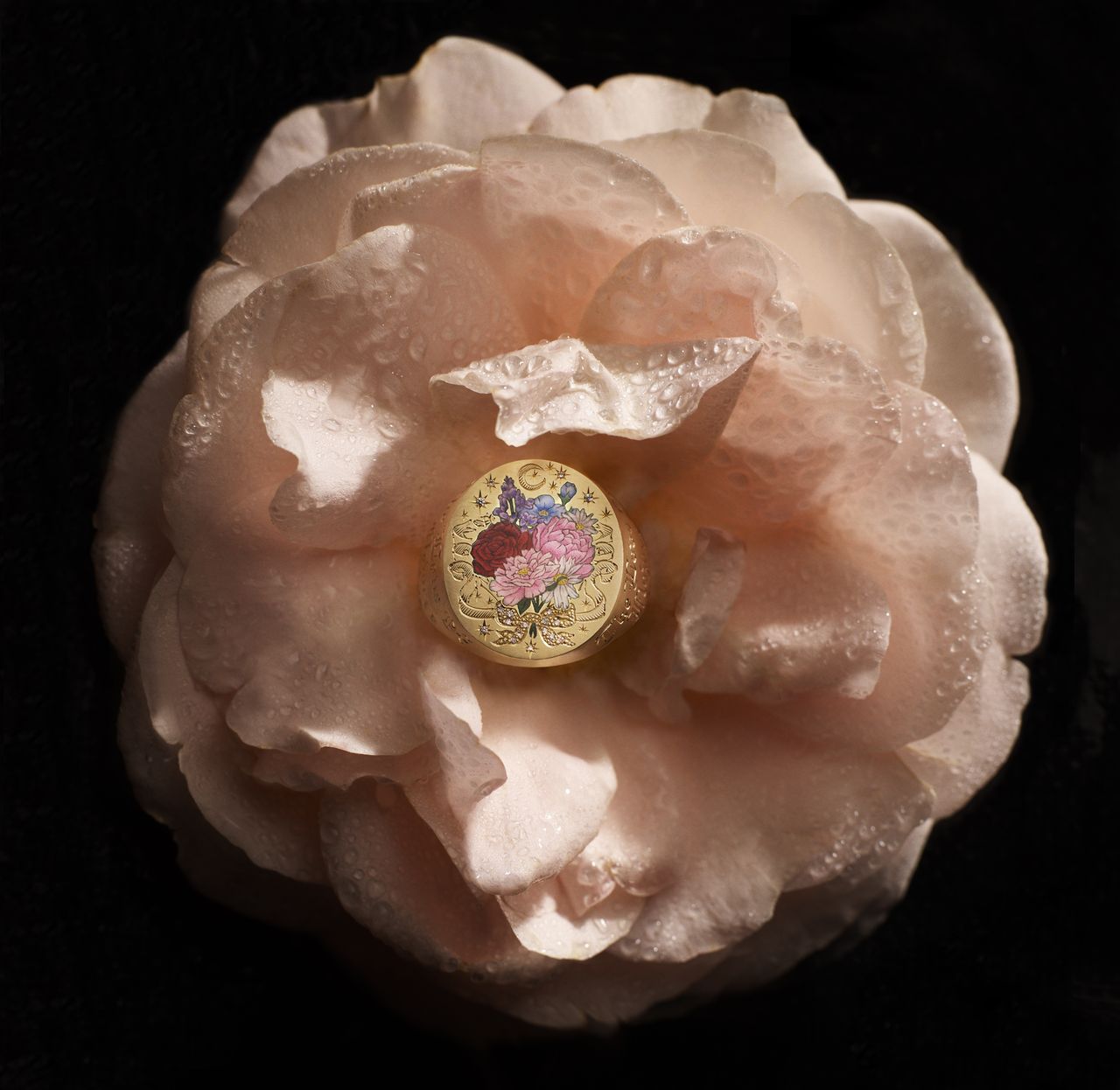 Gold jewellery featuring illustrations of blue and pink flowers