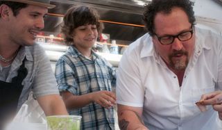 Chef Jon Favreau cooks as John Leguizamo and a boy watch on