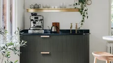 home coffee bar with black cabinets and a silver coffee machine